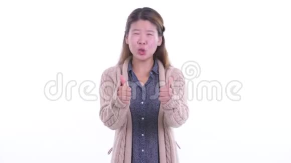 快乐的年轻亚洲女人竖起大拇指为冬天做好准备视频的预览图