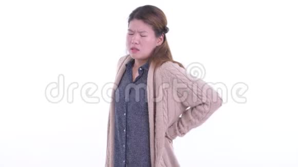 穿着衣服的年轻亚洲女人在冬天背痛视频的预览图