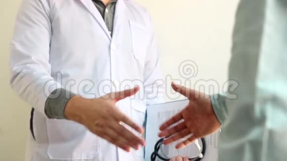医生和病人在医院办公室前握手表示祝贺视频的预览图