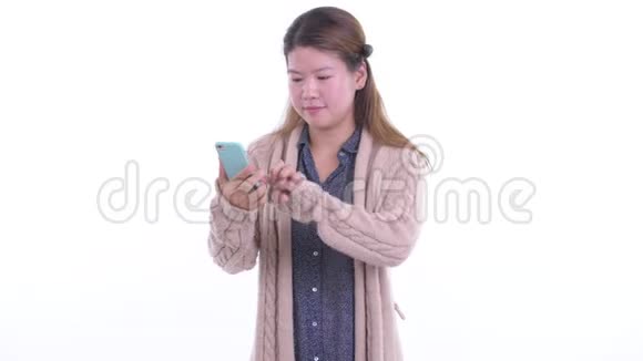 快乐的年轻亚洲女人用电话准备好冬天的好消息视频的预览图