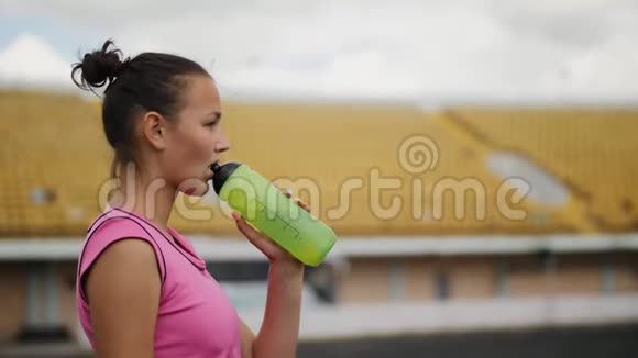 女孩在体育场喝水视频的预览图