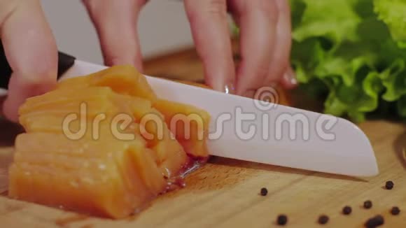 在厨房的木板上切红鱼的近镜头烹饪三文鱼海鲜淡盐鲑鱼切割视频的预览图