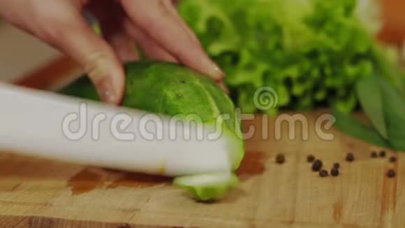 近距离的画面男人手在厨房切味黄瓜新鲜切片沙拉木板侧视视频的预览图