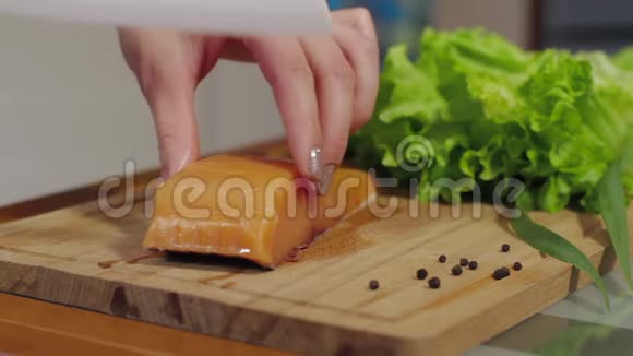 男人在厨房的木板上切红鱼烹饪三文鱼海鲜淡盐鲑鱼切片鲑鱼牛排视频的预览图