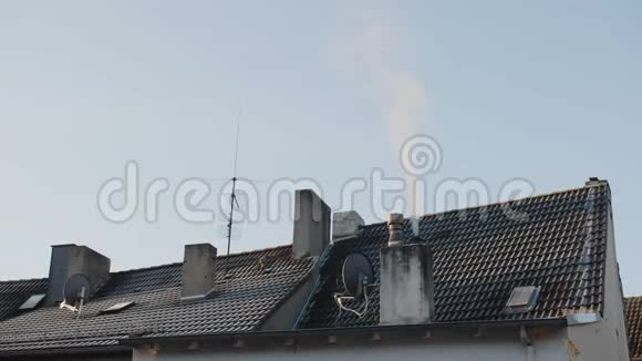 美丽的特写静态的私人住宅屋顶和蓝天烟雾从烟囱出来在寒冷的冬天视频的预览图