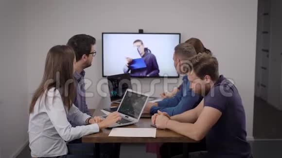 在会议室举行视频会议时一群财务专家正在与公司老板一起观看展示视频的预览图