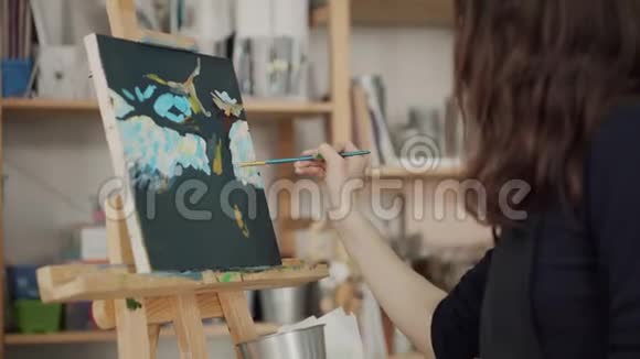 女画家在画室里用白色的笔触作画视频的预览图