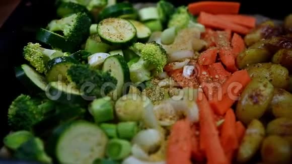 盛满绿色蔬菜的烹饪托盘胡萝卜髌骨撒上大蒜视频的预览图