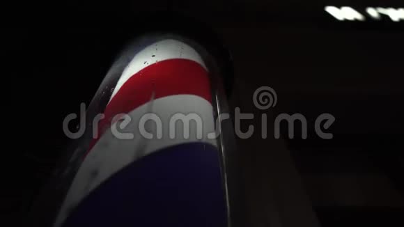 红白蓝理发店街上的招牌一个理发师夜间标志的近镜头视频的预览图