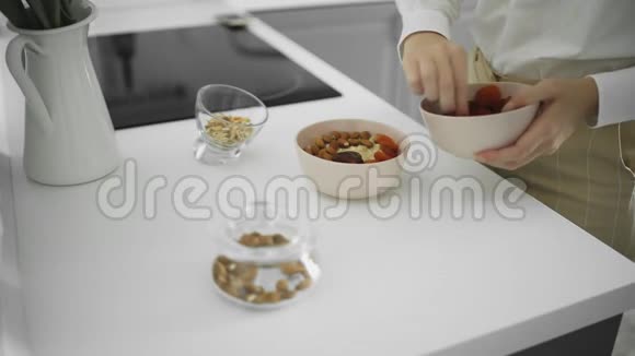 陶瓷碗燕麦粥加香蕉枣杏干坚果健康的早餐和饮食食品视频的预览图