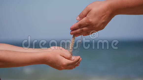 和孩子们一起在海上休息沙子从手掌心倒入孩子手心视频的预览图