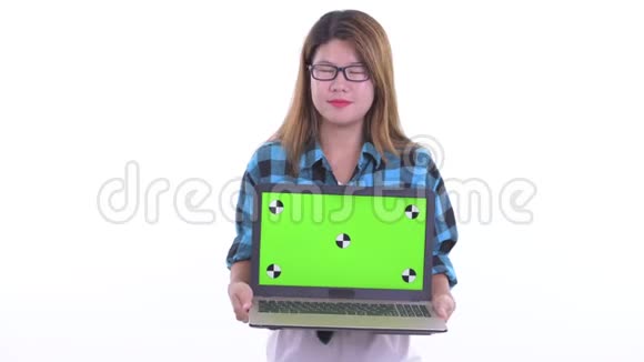 年轻的亚洲时髦女郎一边思考一边展示笔记本电脑视频的预览图