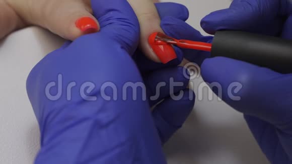 特写专业美容师美甲大师打磨指甲女人正在修指甲用红色盖住指甲视频的预览图