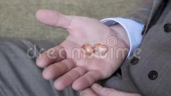 在男人的手掌上是结婚戒指那个人捏着戒指视频的预览图