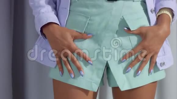 不可辨认的女人穿着淡紫色的金属指甲双手插在口袋里视频的预览图