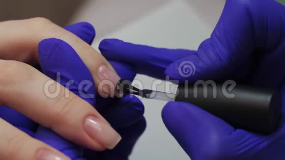 特写专业美容师美甲大师打磨指甲女人正在修指甲用红色盖住指甲视频的预览图