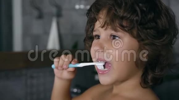 在浴室里清洁牙齿的可爱负责的小男孩近景视频的预览图