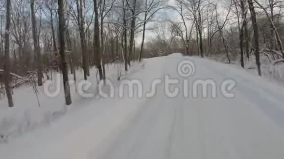 冬天在白雪覆盖的公路上穿过森林视频的预览图