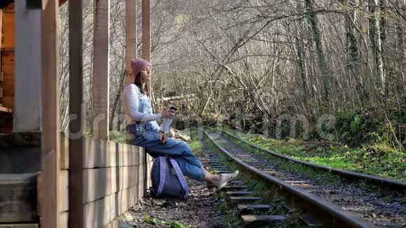 年轻的背包客女士坐在火车站喝水视频的预览图