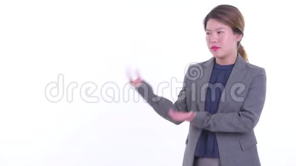 一位衣着光鲜的亚洲女商人一边说话一边展示视频的预览图
