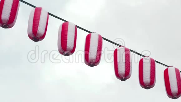 东方纸红白灯笼挂在阴郁的天空背景上悬挂在天空的日本灯笼视频的预览图