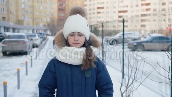 心烦意乱的女孩哭着走在白雪覆盖的街道上视频的预览图