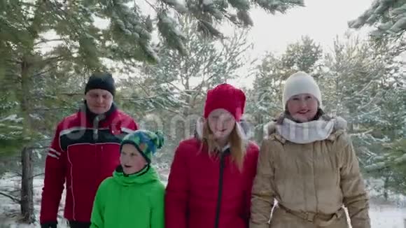 幸福的家庭在白雪覆盖的针叶林中散步视频的预览图