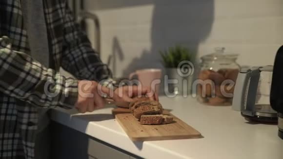 切板上棕色面包切片的特写人类用种子割黑面包视频的预览图