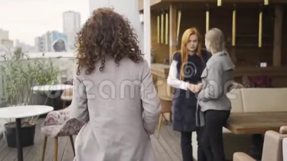两个女朋友看着路过的女人闲聊着她的外表女性友谊八卦视频的预览图
