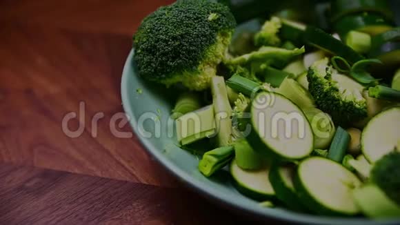 把盛满绿色蔬菜的碗放在木桌上视频的预览图