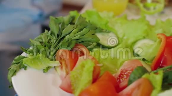 五颜六色的新鲜自制健康沙拉关闭娃娃镜头盘子里的蔬菜男孩手拿黄瓜片视频的预览图