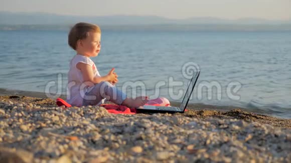 小女孩坐在海边的笔记本上把工作和假期结合起来的新一代人创造力和创造力视频的预览图