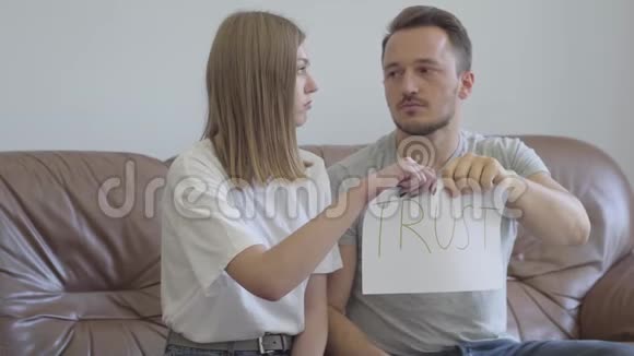 男人和女人撕毁纸上写的信任这个词男女关系中的问题视频的预览图