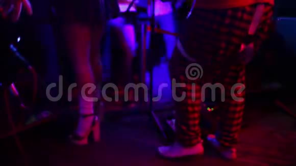 特写照片年轻的时髦女人腿和红色吉他在霓虹灯摇滚音乐家在弹电吉他视频的预览图