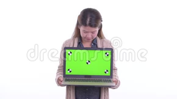 快乐的年轻亚洲女人展示了笔记本电脑看上去很惊讶地准备过冬视频的预览图