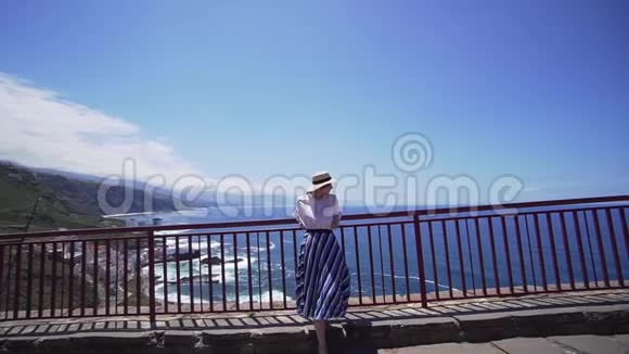 一个孤独的女潮人站在山的边缘在大海的背景下金丝雀视频的预览图