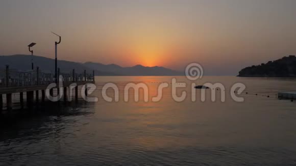 时间推移风景日出山海景观早晨的太阳从山上升起轮廓分明海水光滑视频的预览图