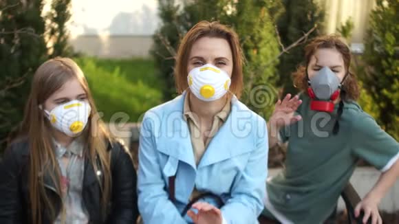 年轻漂亮的女人戴着防护面具两个蒙面的孩子在隔离期间散步冠状病毒流行视频的预览图