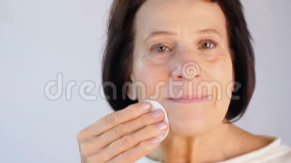 老年妇女用棉垫清洁面部视频的预览图