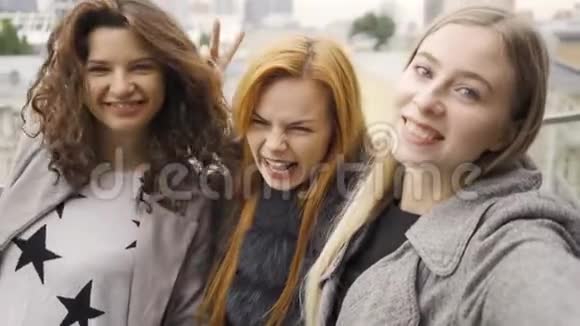 三个漂亮的年轻女朋友在一家咖啡馆的夏天露台上自拍视频的预览图