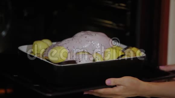 用土豆在烤箱里烤制整只烤鸡女人决定鸡肉是否煮熟女性手视频的预览图