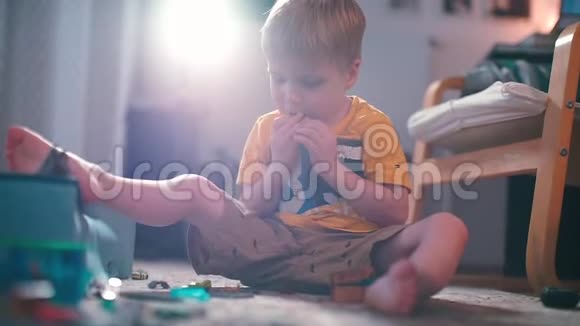 一个男孩和一个设计师在幼儿园里坐在地板上玩视频的预览图
