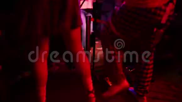 特写照片年轻的时髦女人腿和红色吉他在霓虹灯摇滚音乐家在弹电吉他视频的预览图