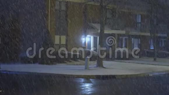 汽车开得很慢夜间在住宅区的街道上积雪覆盖视频的预览图