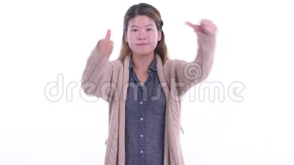 一位困惑的亚洲年轻女性在冬天选择竖起大拇指和竖起大拇指视频的预览图