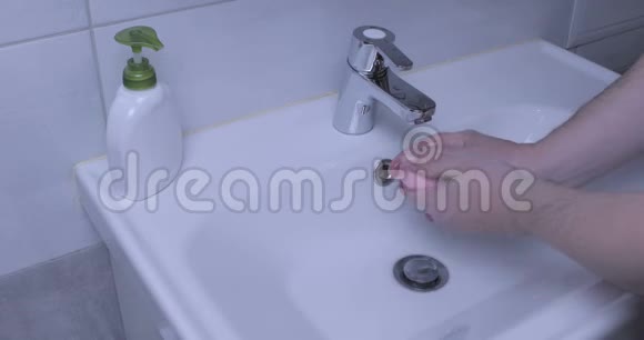 男人在家里的浴室里洗手COVID192020年大流行病视频的预览图