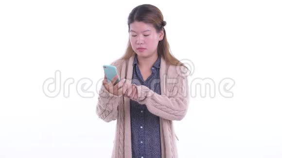 戴着帽子的年轻亚洲女人在冬天用电话接坏消息视频的预览图
