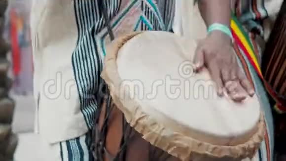 穿着民族服装的非洲鼓手在djembe鼓上演奏音乐家在非洲鼓上敲打节奏黑色视频的预览图