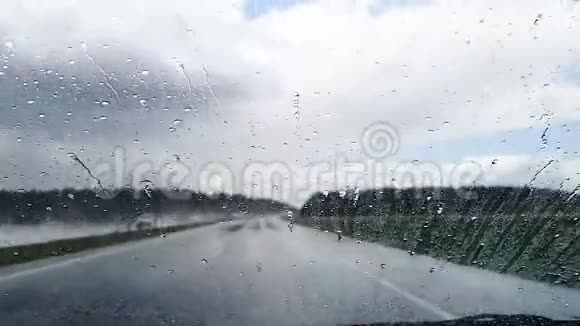雨天从高速公路上行驶的汽车挡风玻璃上滴下的雨滴视频的预览图
