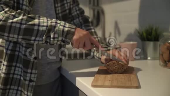 切板上棕色面包切片的特写人类用种子割黑面包视频的预览图